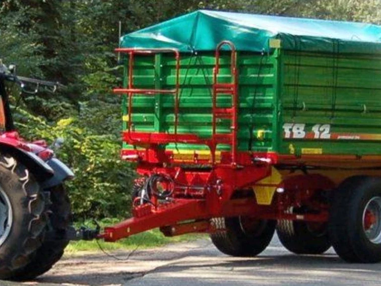 czerwony traktor z podłączoną naczepą